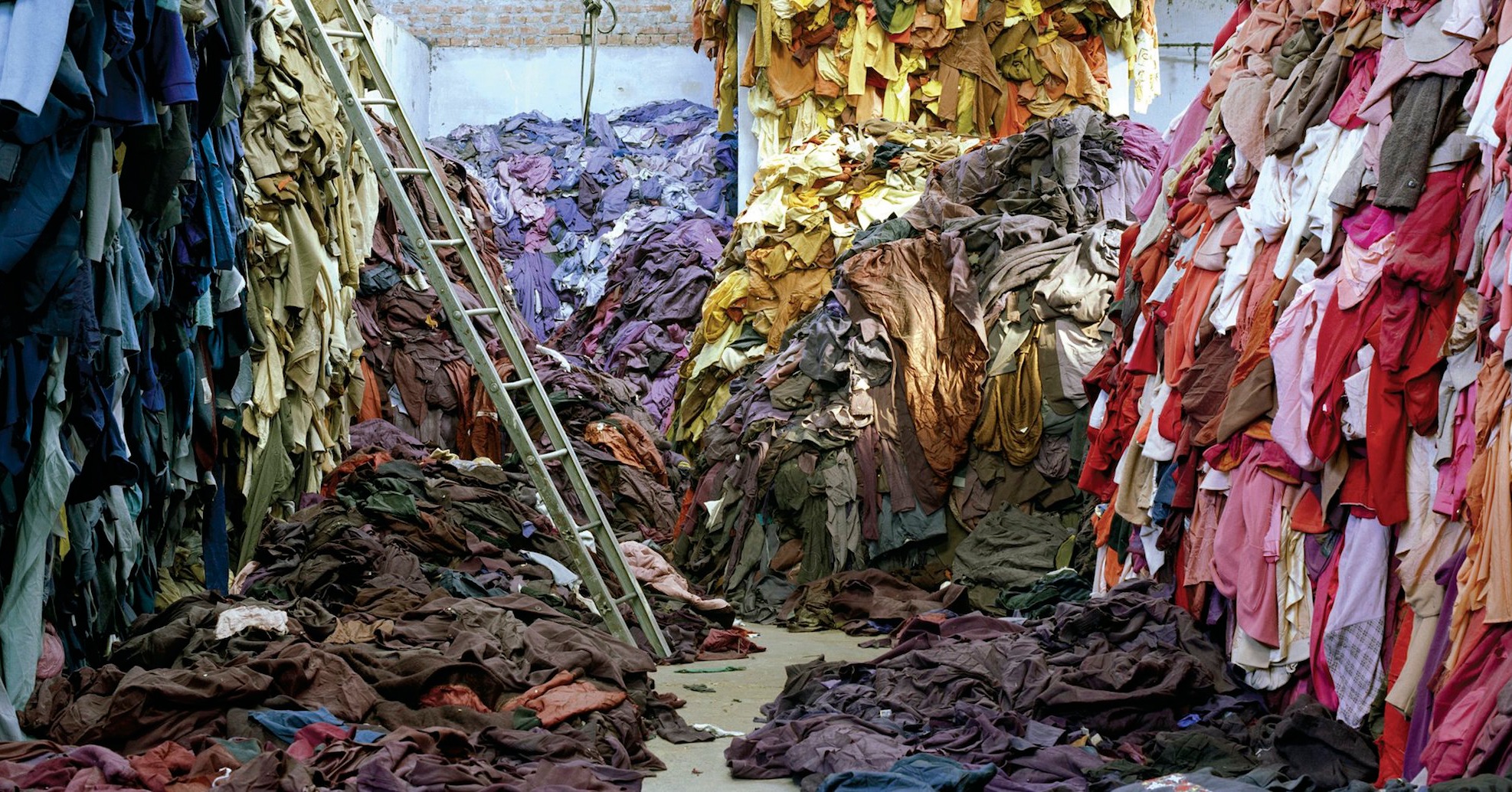Huge piles of clothes with a ladder to climb to the top